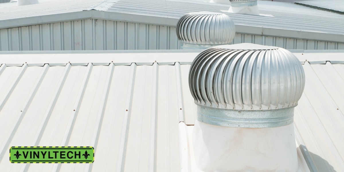 Close-up view of a commercial metal roof with ventilation systems, highlighting durability and energy efficiency, featuring the Vinyltech logo.