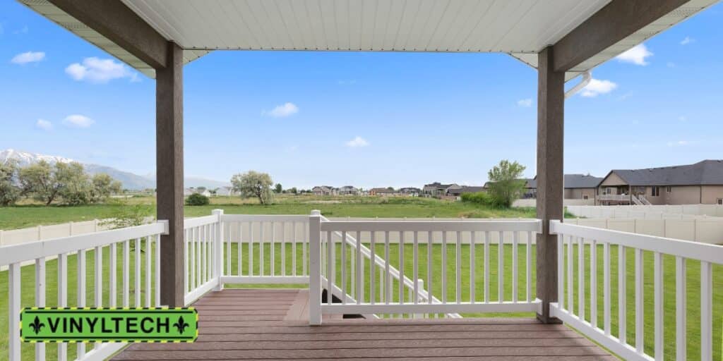 A custom patio cover with white railings and brown decking, overlooking a lush green backyard with mountain views. This Vinyltech installation provides shade and enhances outdoor living in a picturesque setting.