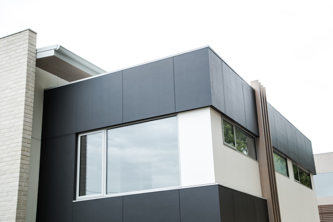 Beautiful modern suburban house with a brand new, pristine roof sparkling under a clear, sunny sky, showcasing excellent c...