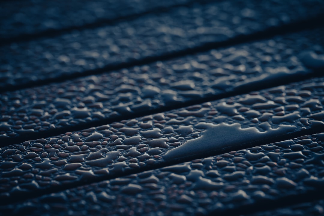 A close-up photograph showing the texture of old, weathered asphalt roof shingles, illustrating the effects of age and climate on a home.