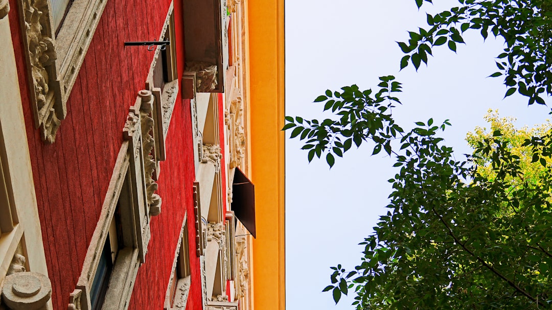 A professional contractor in a hard hat discusses repair plans with a homeowner, pointing towards the exterior of their storm-damaged house.